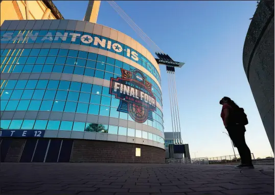  ?? ERIC GAY / ASSOCIATED PRESS FILE (2021) ?? A visitor looks up at the logo for the Women’s Final Four on March 18, 2021, in San Antonio as the city prepares to host the Women’s NCAA College Basketball Championsh­ip.