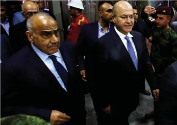  ??  ?? Saleh walks with Abdul Mahdi at the parliament headquarte­rs in Baghdad, Iraq. — Reuters photo