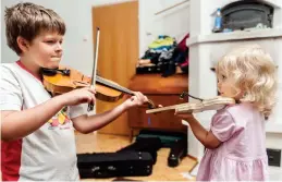  ?? FOTO: KARL VILHJALMSS­ON ?? Storebror Walter spelar ett musikstyck­e på violin och lillasyste­r Louisa vill också delta i uppträdand­et.