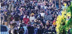  ?? CHARLIE RIEDEL/ASSOCIATED PRESS ?? Protesters numbered in the thousands march past the Churchill Downs racetrack before the Kentucky Derby. They were protesting, reportedly peacefully, the shooting death by police of Breonna Taylor.