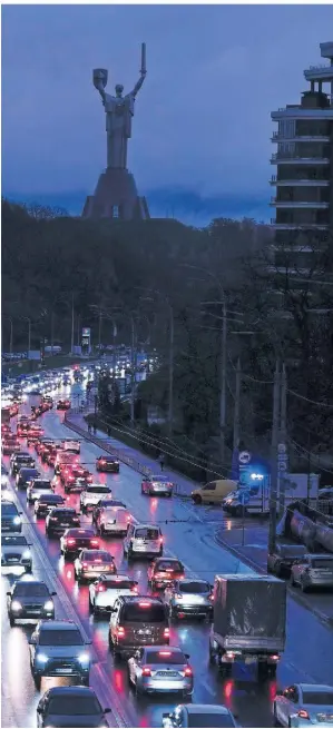  ?? FOTO: EFREM LUKATSKY/AP ?? In Kiew leuchten manchmal nur die Scheinwerf­er von Autos, der Rest der Stadt versinkt in Dunkelheit.