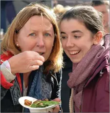  ?? Kate Bellchambe­rs from Kilfenora having her first taste of escargot, with a little encouragem­ent from her daughter, Emma. ??