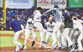  ?? Julio Aguilar / Getty Images ?? The Rays’ Travis d’Arnaud is congratula­ted by teammates after hitting a walkoff homer against the Yankees on Saturday.