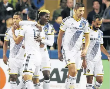  ?? Ted S. Warren Associated Press ?? SEBASTIAN LLETGET, second from left, congratula­tes Galaxy teammate Gyasi Zardes after his goal in the team’s playoff loss Wednesday to Seattle. Lletget is believed to be listening to offers from Europe.