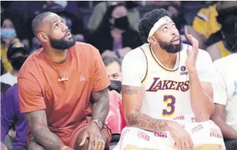  ?? AP ?? Los Angeles Lakers’ LeBron James (left) sits on the bench with forward Anthony Davis during the first half of a preseason NBA basketball game against the Brooklyn Nets on Sunday in Los Angeles.
