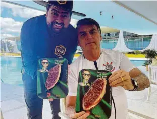  ?? @churrascod­otche no Instagram ?? O presidente Bolsonaro, ao lado do responsáve­l pelo preparo do churrasco, que nas redes sociais se apresenta como “churrasque­iro dos artistas”