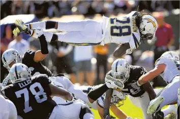  ?? Thearon W. Henderson Getty Images ?? MELVIN GORDON dives for a one-yard touchdown late in the first half at Oakland. Gordon also scored on a six-yard pass early in the fourth quarter before the Chargers won it on Nick Novak’s field goal.