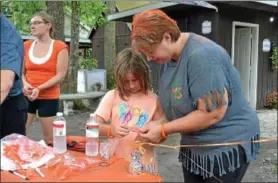  ??  ?? Angela Nace and daughter, Madlynne, put on their bands for the Zumba fundraiser Aug. 5.