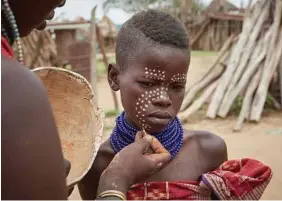  ??  ?? A youth has his face painted in Dus, Ethiopia. Dams are threatenin­g to upend the lives of tribes that depend on the Omo River for survival.