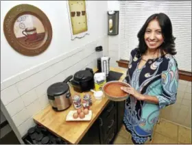  ?? CATHERINE AVALONE — NEW HAVEN REGISTER ?? Johanna Torres makes a flan in her Branford kitchen.