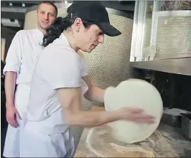  ??  ?? Fabrizio Caprioli (left), head chef at Rosalie, looks on as pizza chef Vincenzo Butticé makes a margherita pizza. Butticé’s pizzas are the only thing better than average.