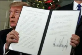  ?? EVAN VUCCI — THE ASSOCIATED PRESS ?? President Donald Trump holds up a proclamati­on to officially recognize Jerusalem as the capital of Israel, in the Diplomatic Reception Room of the White House, Wednesday in Washington.