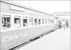  ??  ?? Passengers look out from the coach windows of a standard economy class train operated by Pakistan Railways sitting at Karachi Cantonment railway station in Karachi.