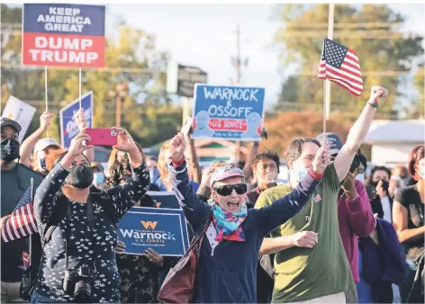  ?? FOTO: JESSICA MCGOWAN/AFP ?? Anhänger der Demokraten jubeln ihren Senatskand­idaten in Marietta, Georgia, zu.