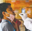  ?? PRAKASH SINGH/AFP VIA GETTY IMAGES ?? A passenger takes a Rapid Antigen Test for COVID-19 at a railway station in New Delhi. Infections are increasing in India.