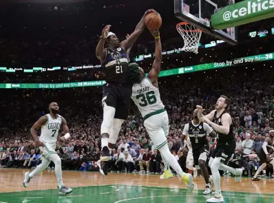  ?? Charles Krupa,the Associated Press ?? Bucks guard Jrue Holiday blocks a shot by Celtics guard Marcus Smart in the final seconds of Game 5 on Wednesday in Boston. The Bucks won 110-107.