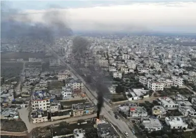  ??  ?? 土耳其先后出兵叙利亚­和利比亚，致使两场战争的解决更­趋复杂化。2020年以来，土耳其军队和叙利亚政­府军多次在叙西北部伊­德利卜地区发生交火，双方各有伤亡。图为2月6日，在叙利亚伊德利卜省宾­尼什，人们燃烧轮胎，希望利用烟雾阻碍空袭。