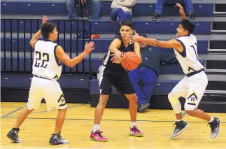  ?? ADOLPHE PIERRE-LOUIS/JOURNAL ?? Volcano Vista’s Ben Manzano, center, gets a pass between Atrisco Heritage defenders Diego Ortega, left, and Vince Gonzales during Tuesday’s game. Volcano Vista took a 63-58 victory.