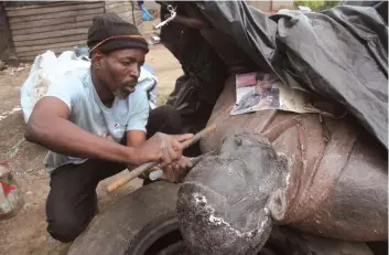  ??  ?? Petros Ndlovu works on a life-size statue at his “workshop” along the Mukuvisi River banks