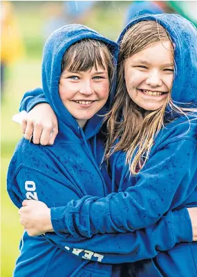  ?? Picture: Steve Brown. ?? Smiles amid the rain as two friends enjoy a cuddle at the Lundin Mill Primary School ceremony.