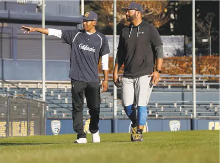  ?? Michael Macor / The Chronicle ?? Darren Baker (left), a freshman infielder at Cal, walks at Evans Diamond with coach and “big brother” Noah Jackson.