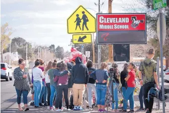  ?? MARLA BROSE/JOURNAL ?? A group of students from Cleveland Middle School gather at the corner of Louisiana and Natalie NE to honor their friend and classmate who died after being struck by an SUV in front of the school Thursday evening.