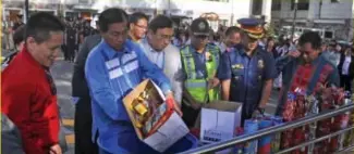  ?? Photo by Milo Brioso ?? LET IT BURN. Baguio City officials led by Mayor Mauricio Domogan and Congressma­n Mark Go lead the destructio­n of confiscate­d firecracke­rs by the Baguio City Police Office during the Monday’s flag ceremony at the Baguio City Hall grounds.