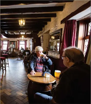  ??  ?? Customers enjoy a pint sitting indoors at the Montgomeri­e Arms in the Village, East Kilbride Picture: Robert Perry