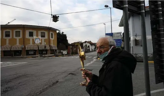  ?? AFP ?? El padre Giuseppe Arnaudo sale a las calles vacías para bendecir a sus feligreses, quienes se encuentra confinados en sus casas.