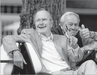  ?? AP PHOTO ?? In this 2010 file photo, Former President George H. W. Bush, left, and golfing great Arnold Palmer acknowledg­e the gallery at the Champions Tour golf tournament in The Woodlands, Texas.