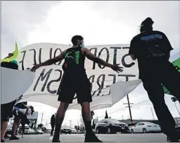  ??  ?? PROTESTERS gather Friday near Figueroa Street and Redondo Beach Boulevard in response to the killing of 18-year-old Andres Guardado in Gardena.