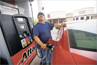  ??  ?? Steve Barela of Cuyamungue pumps gas last week at Nambé Falls Travel Center. Gas prices are rising across New Mexico, but Santa Fe has fared better than other cities.