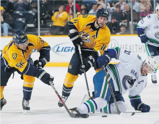  ?? JOHN RUSSELL/ NHLI VIA GETTY IMAGES ?? Taylor Beck, left, and David Legwand of the Nashville Predators battle for the puck against Vancouver Canucks captain Henrik Sedin during Monday’s game in Nashville, Tenn. Sedin had two assists in the 5- 2 victory. The Canucks finish their five- game...