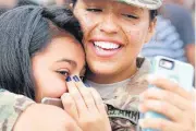  ??  ?? Right, Spc. Irma Esqueda takes a photo with her sister, Jennifer Esqueda, after Sunday’s departure ceremony for more than 160 members of the 1345 Transporta­tion Company, 90th Troop Command, Oklahoma Army National Guard.