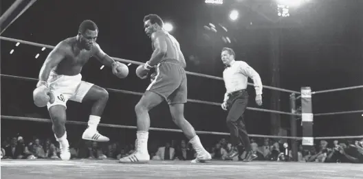  ?? AP ?? World heavyweigh­t champion Joe Frazier, left, is knocked down in the second round of his title fight against George Foreman in Kingston, Jamaica, on Jan. 22, 1973.