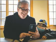  ?? NATHAN BURTON/Taos News ?? Chip Taylor and his son Danny FaceTime his wife Lidia on Wednesday (March 16) in Taos. Chip and Danny, now staying with a friend in the Village of Questa, fled the war in Ukraine. Apart from leaving behind friends and family, the Taylor’s left behind a burgeoning rehabilita­tion and farm business.