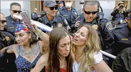  ?? Rich Pedroncell­i Associated Press ?? TARA THORNTON, right, a co- founder of Freedom Angels Foundation, huddles with other demonstrat­ors detained during a protest against stay- at- home orders.