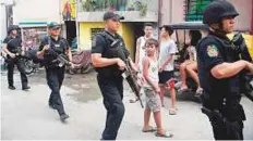  ?? Reuters ?? Members of Philippine police hold their weapons during an anti-drugs operation in Mandaluyon­g, Metro Manila.