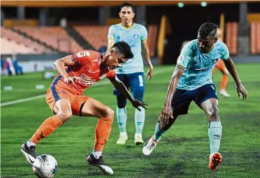  ?? — Bernama ?? Eyes on the ball: Felda United’s Syahmi Zamri (left) trying to get past Pahang’s Dinesh Rajasingam during the Super League match at the Tun Abdul Razak Stadium in Jengka.