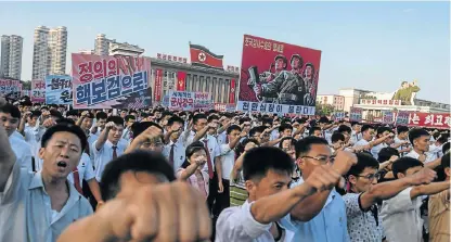  ?? /AFP Photo ?? Baring arms: People wave banners and shout slogans as they attend a rally in support of North Korea’s stance against the US, on Kim Il-sung square in Pyongyang on Wednesday.