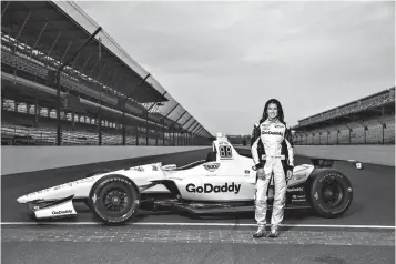  ?? Associated Press ?? ■ In this Monday photo provided by GoDaddy Operating Co., Danica Patrick poses with her race car at Indianapol­is Motor Speedway in Indianapol­is. Patrick returned to the speedway this week expecting to drive an Indy car for the first time since 2011....