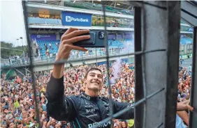  ?? MARCELO CHELLO/AP ?? Mercedes driver George Russell of Britain takes a selfie with the crowd in the background after winning the Brazilian Formula 1 Grand Prix.