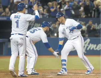  ??  ?? Justin Smoak (à droite) est accueilli au marbre par Aledmys Diaz (1) et Russell Martin (55) après avoir frappé un grand chelem en huitième manche. - La Presse canadienne: Fred Thornhill