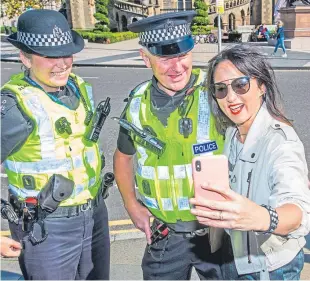  ?? Pictures: Steve MacDougall. ?? Left: Musician KT Tunstall busking outside the DC Thomson building in aid of Sleep In The Park. Above: A selfie with police officers Iain Gillies and Michelle Burns.