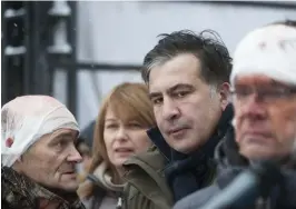  ?? FOTO: TT/AP/EVGENIY MALOLETKA ?? Micheil Saakasjvil­i tillsamman­s med personer som skadats vid sammandrab­bningar med ukrainsk polis.