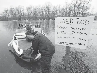  ?? ANDREW VAUGHAN / THE CANADIAN PRESS ?? Rob Dekany, known as Uber Rob, ferries stranded passengers at Darlings Island, N.B., on Thursday as the Kennebecas­is River flooded the only road into the community. Dekany has refused to accept any payment.