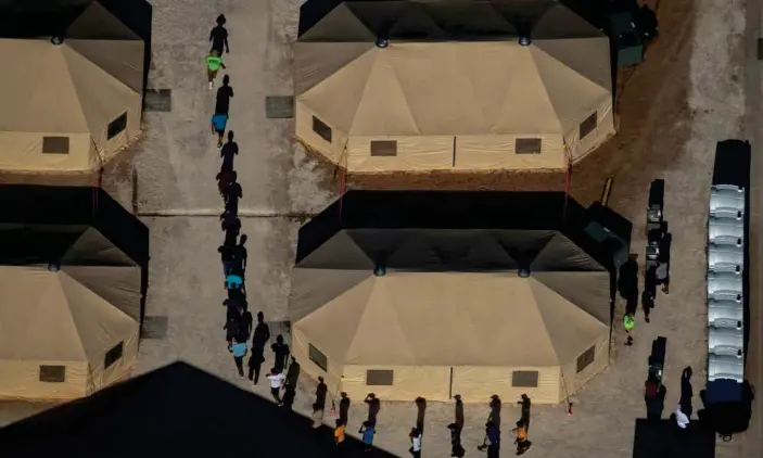  ?? Photograph: Mike Blake/Reuters ?? Migrant children are led by staff at a detention facility in Tornillo, Texas, in June 2018. As of September, 1,677 children had yet to be reunited with parents.