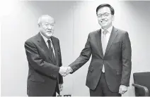  ?? Yonhap ?? Finance Minister Choi Sang-mok, right, and Japan’s Finance Minister Shunichi Suzuki shake hands ahead of their meeting in Washington, Tuesday in this photo provided by finance ministry.
