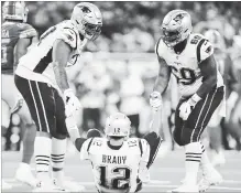  ?? REY DEL RIO GETTY IMAGES ?? Trent Brown, left, of the New England Patriots and Shaq Mason help quarterbac­k Tom Brady off the field after a sack during the second half of an NFL game at Ford Field in Detroit on Sunday.