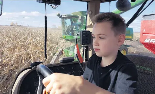  ??  ?? Les enfants participen­t aux travaux à la ferme de leurs parents depuis des siècles. Antoine Jodoin, huit ans, s’initie graduellem­ent à la conduite du tracteur, sous la supervisio­n d’un adulte.